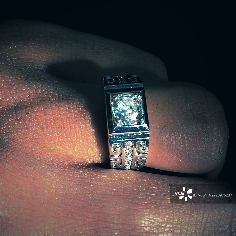 黑暗房间中钻石戒指的特写镜头图片素材