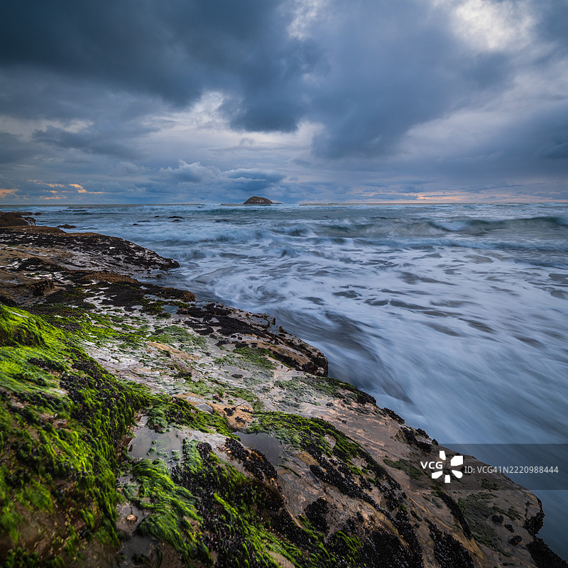 壮丽的山脉风景，流动的水和阴云密布的天空。图片素材