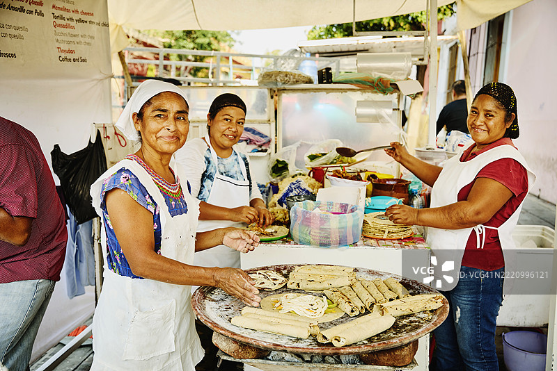 宽镜头拍摄女性在食品摊位制作法拉塔和玉米饼。图片素材