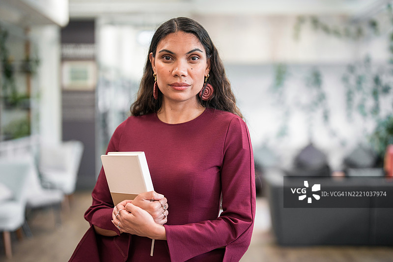 自信的年轻土著女商人在现代办公室工作图片素材