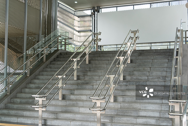 地铁站有一个带金属扶手的楼梯。图片素材