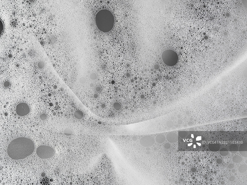 压花泡沫与肥皂泡混合在白色丝绸布上。图片素材