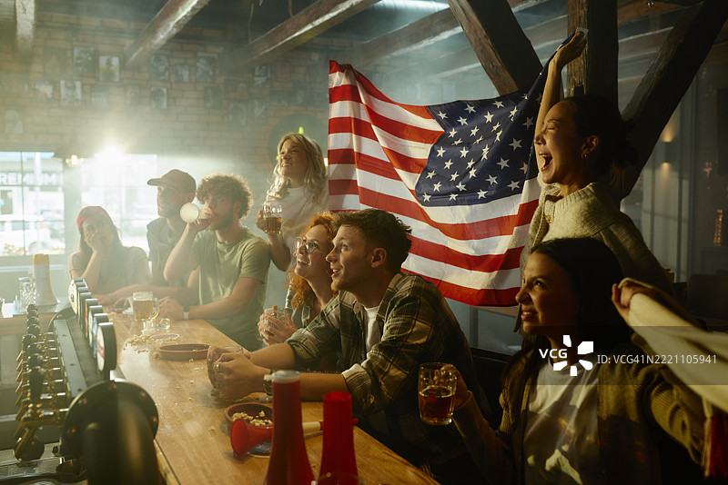 快乐的球迷在酒吧里观看世界冠军比赛。图片素材