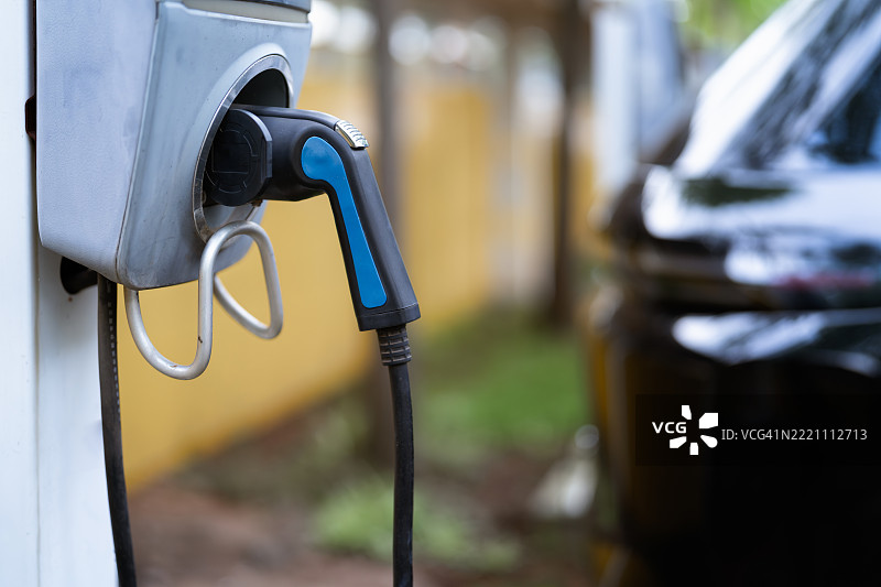 城市环境中的电动车充电站与电源插头图片素材