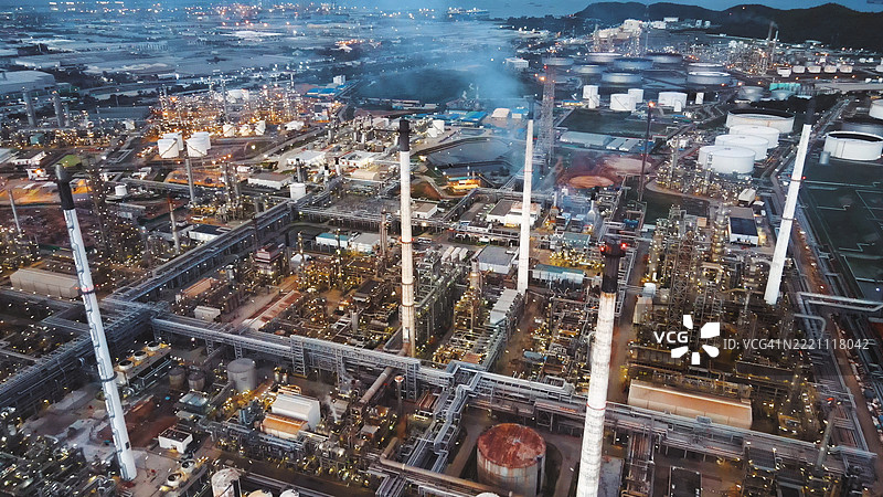 石油炼油厂综合体，塔楼和排放由无人机捕捉，工业厂房配有管道和烟囱，代表能源生产图片素材