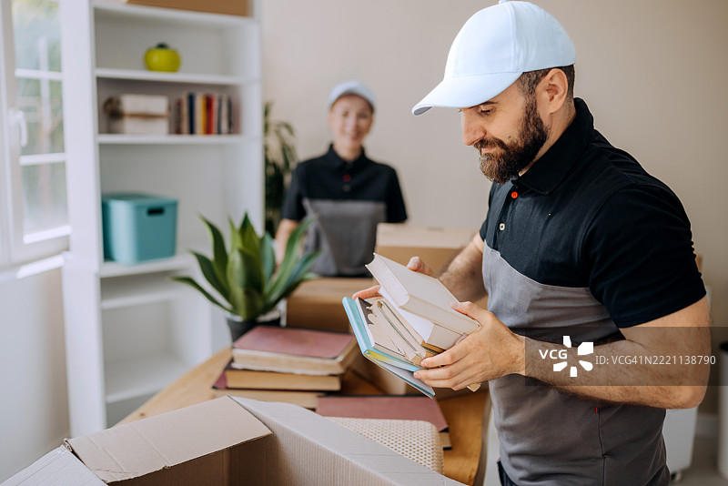 专业搬运工将书籍装入纸箱中图片素材