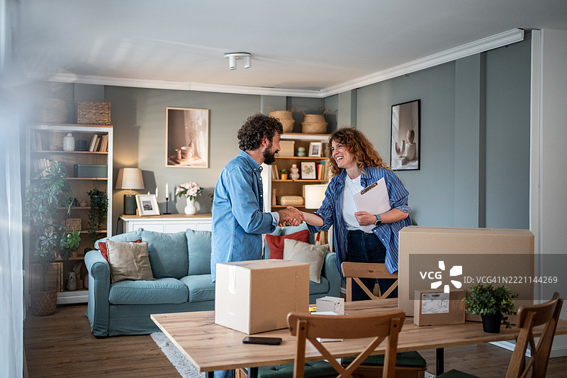 一对情侣在客厅打包纸箱，他们在处理私事。图片素材