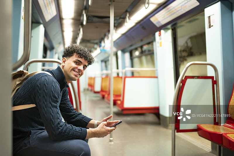 游客在地铁上坐着使用智能手机图片素材