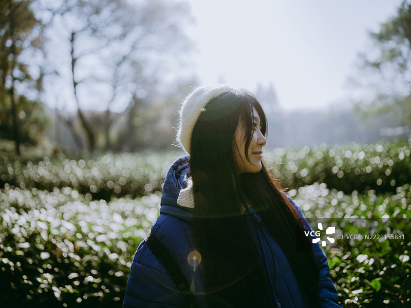 一位年轻的亚洲女性站在山谷中的茶园里图片素材
