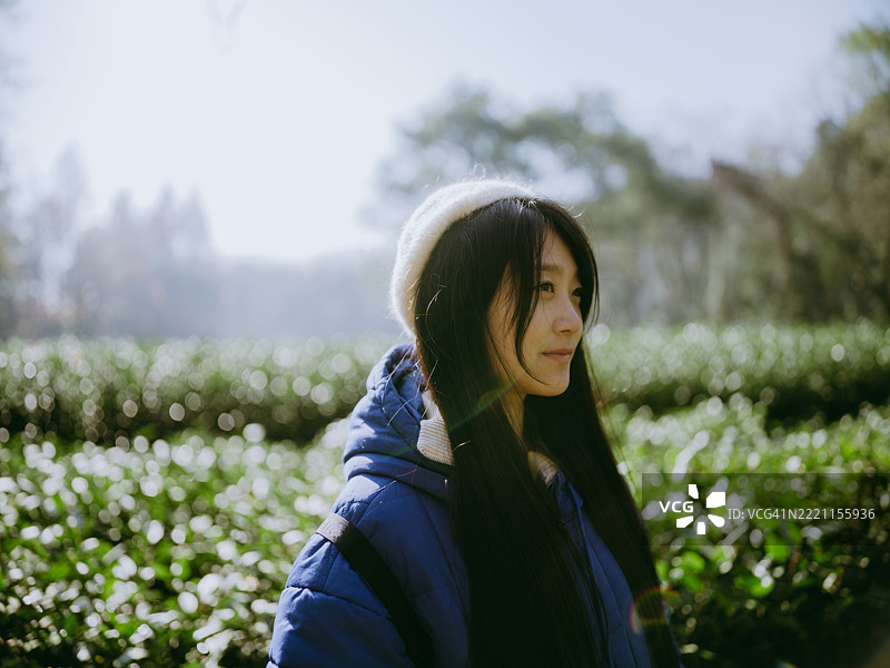 一位年轻的亚洲女性站在山谷中的茶园里图片素材