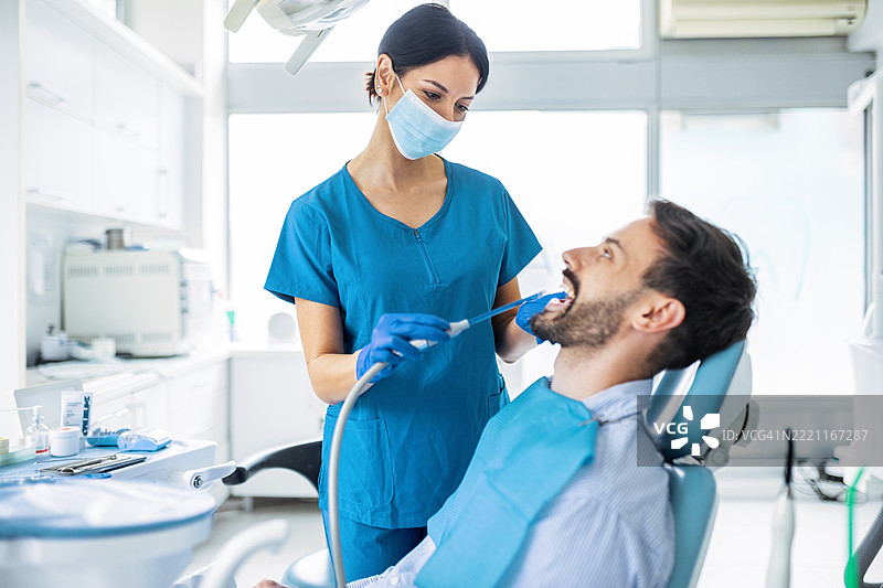 女性牙科卫生员在椅子上为患者治疗图片素材