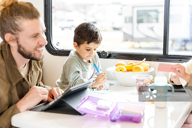家庭房车教育：孩子与爸爸一起学习图片素材