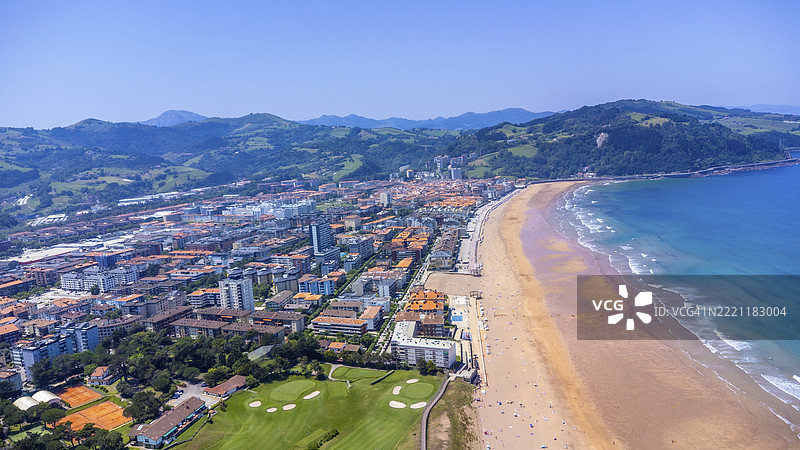 西班牙吉普斯夸的扎劳茨空中视角，展示了城市景观与沙滩和蓝色海浪在晴朗夏日天空下的交汇。图片素材