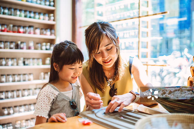 母亲和女儿在手工艺店一起制作手工珠宝图片素材