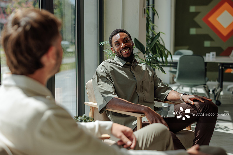 两位商人在办公室的扶手椅上交谈图片素材