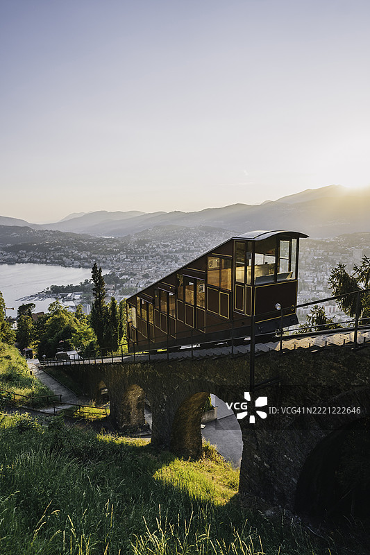 缆车穿越湖泊和城市，向山顶驶去图片素材