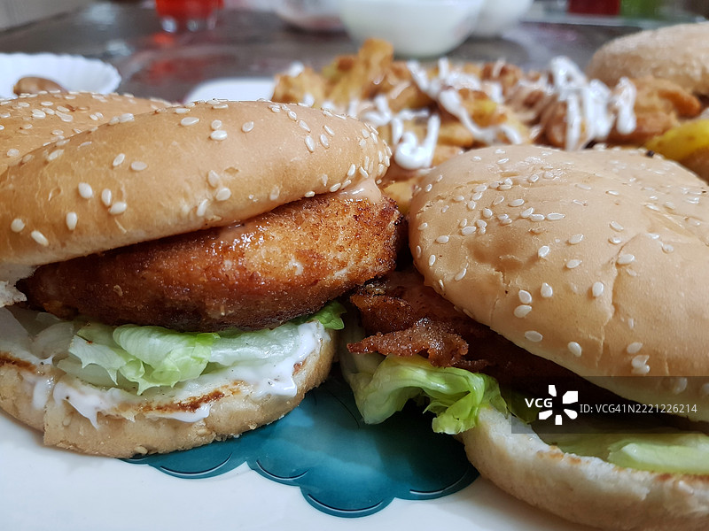 准备好食用的鸡肉汉堡特写，摆放在盘子上。图片素材