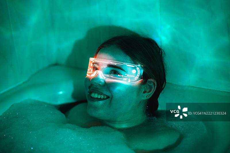 快乐的年轻女性在洗澡时使用智能眼镜图片素材