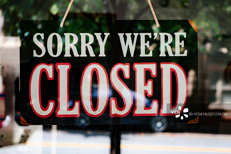 “抱歉，我们关门了”标志挂在商店的门上图片素材