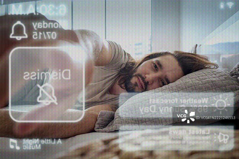 一个男人醒来，闹钟响起，他伸手去关掉闹钟，从设备的视角看。图片素材