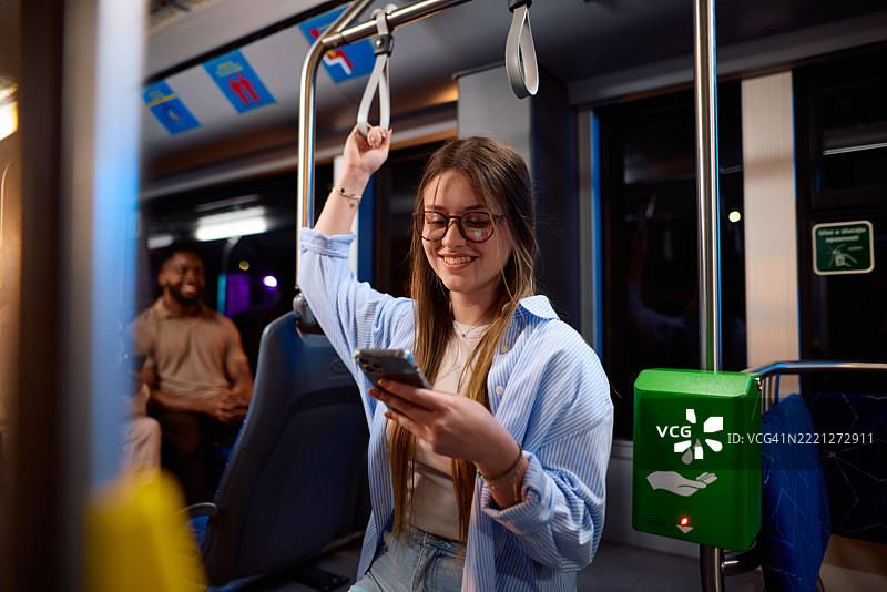 年轻女性在现代电车上通勤时使用智能手机图片素材