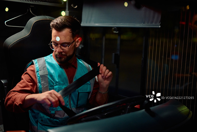 专业卡车司机在开始夜班前系好安全带图片素材