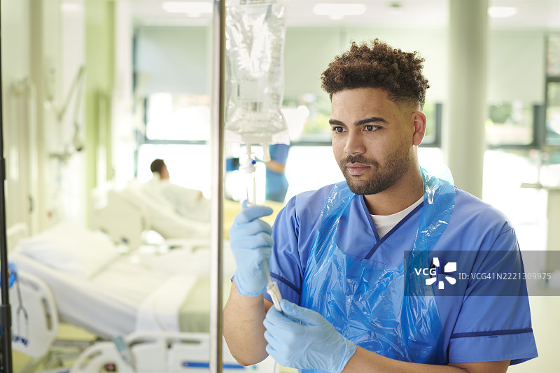 男护士正在调整静脉输液滴注器图片素材