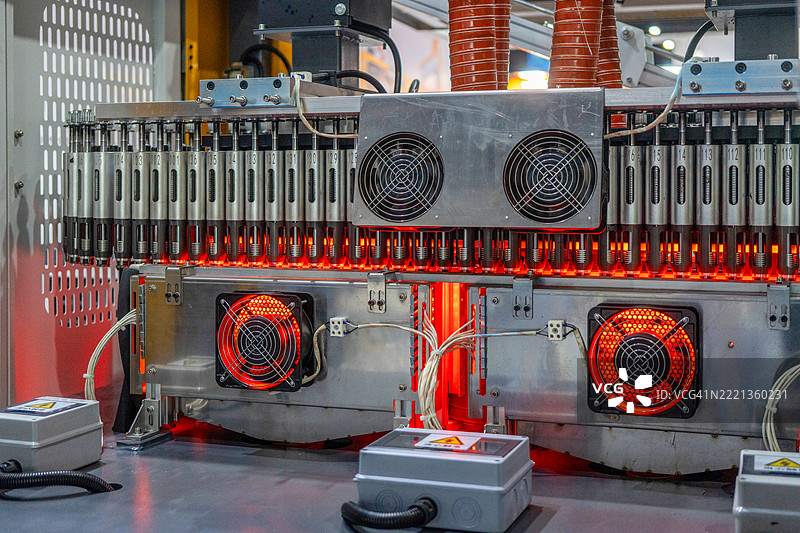 特写镜头展示小型机器人手臂操控小白巧克力板作为样品在工业建筑中移动。图片素材