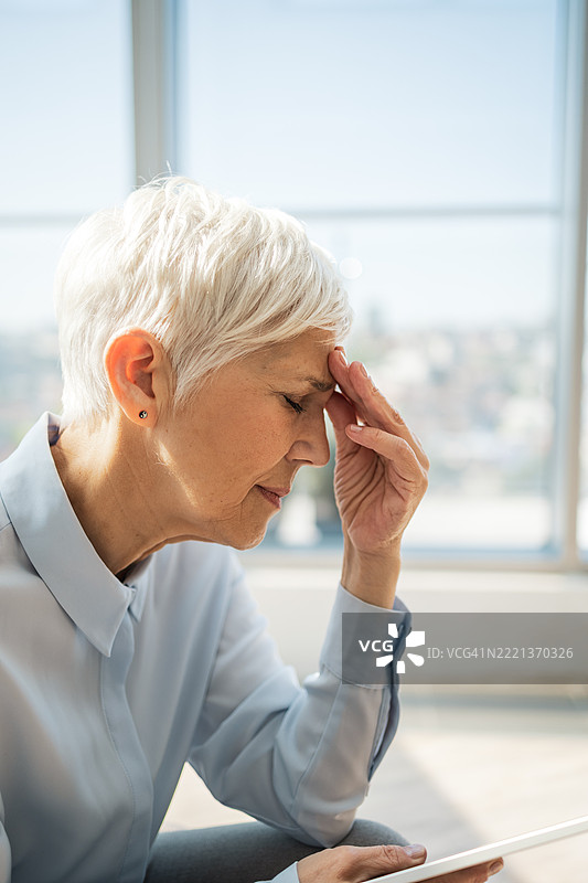 在现代办公室环境中，神情沉思的女性图片素材