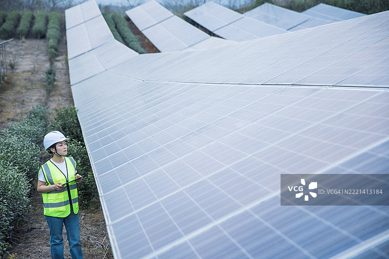 绿色能源。女性工程师在太阳能发电厂。图片素材