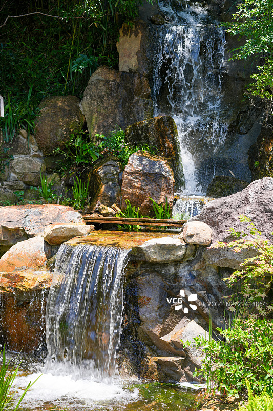 郁郁葱葱的绿树环绕下的宁静瀑布图片素材