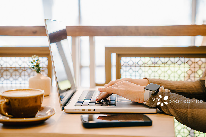 特写镜头下的女性使用笔记本电脑。图片素材