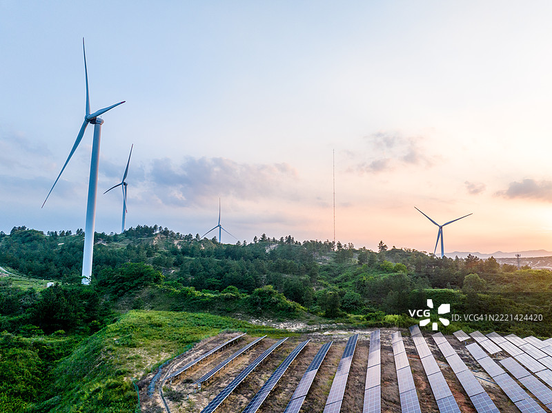 夏日日出时的太阳能发电场和风力涡轮机图片素材