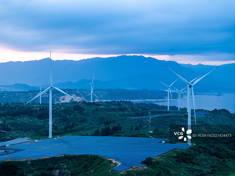 夏日日出时的太阳能田和风力涡轮机图片素材