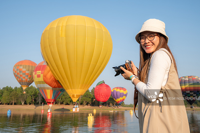 在泰国清莱省参加热气球节的快乐亚洲女性。热气球节一年四季在许多地方定期举行。图片素材