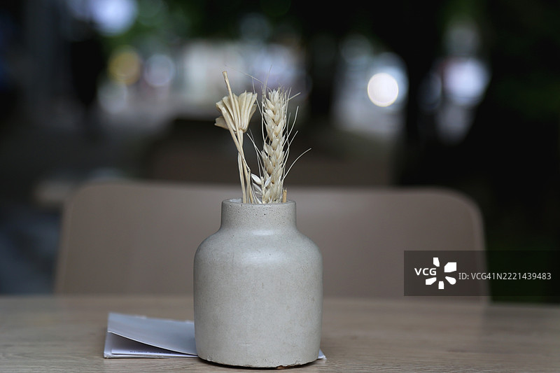 空荡荡的人行道咖啡馆，木桌和优雅的装饰细节映衬模糊的城市街道背景图片素材