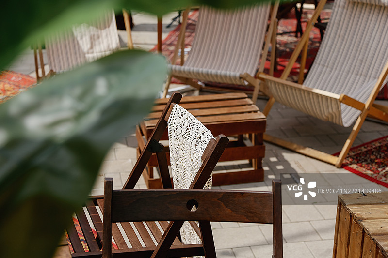 人行道咖啡馆的舒适休闲区，配有躺椅、遮阳伞和盆栽植物，适合放松休息的时光图片素材