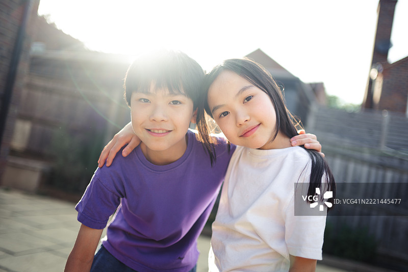 美丽的亚洲男孩和女孩面带愉快的微笑看向镜头图片素材
