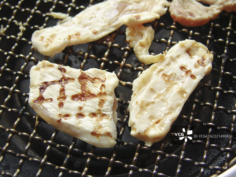 烤鸡肉片在烧烤炉上图片素材