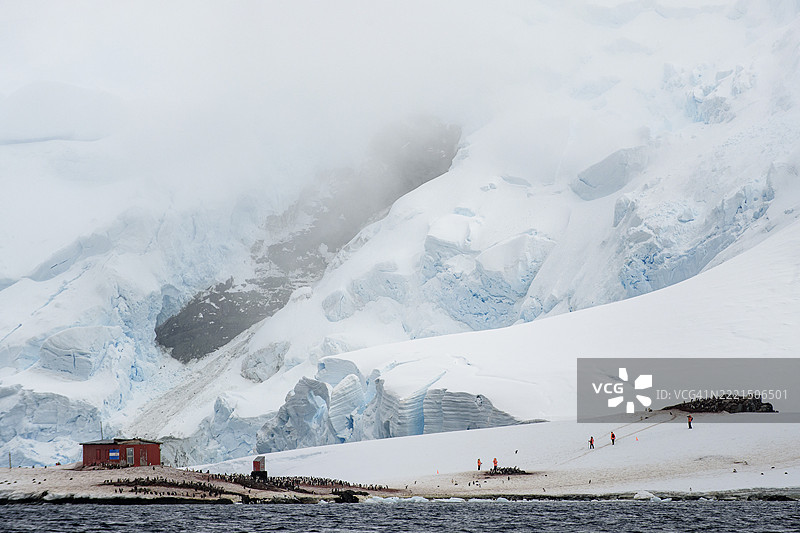 米克尔森港口的戏剧性雪景与游轮游客，南极洲图片素材