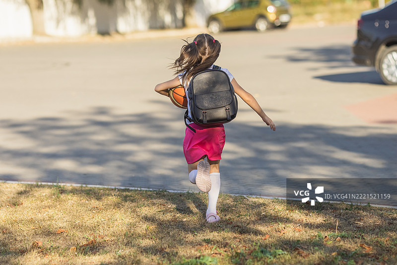 女学生在人行道上奔跑图片素材
