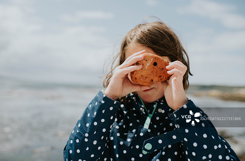 小女孩在岩石海滩上图片素材