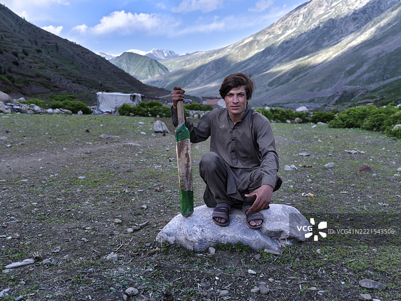 年轻的古贾尔游牧民在巴基斯坦的山脉中手持板球棒，留有空白空间图片素材