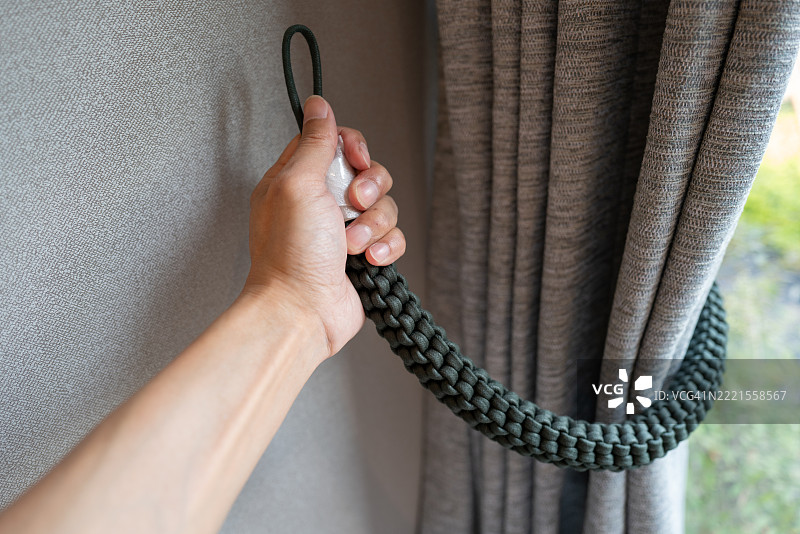 手触碰窗帘绑带图片素材