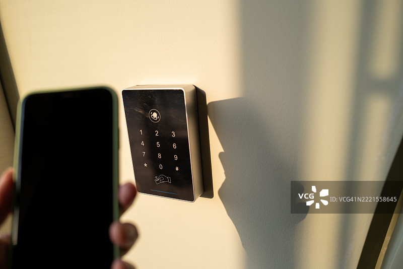 Close-up of holding a smartphone controlling a key card reader图片素材