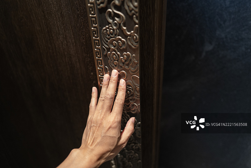 手放在带有浮雕设计的木板上图片素材