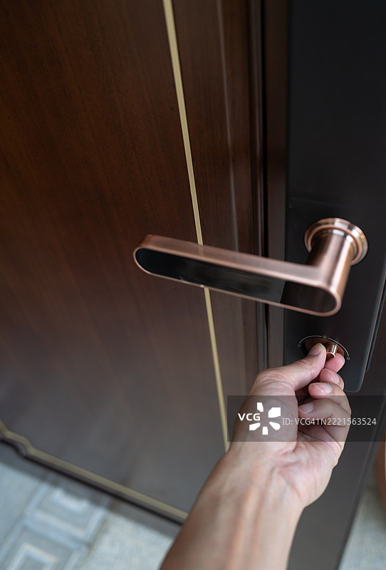 手握木门上的门把手图片素材