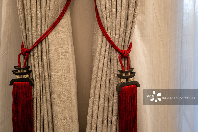 灰色窗帘上的红色流苏绑带图片素材