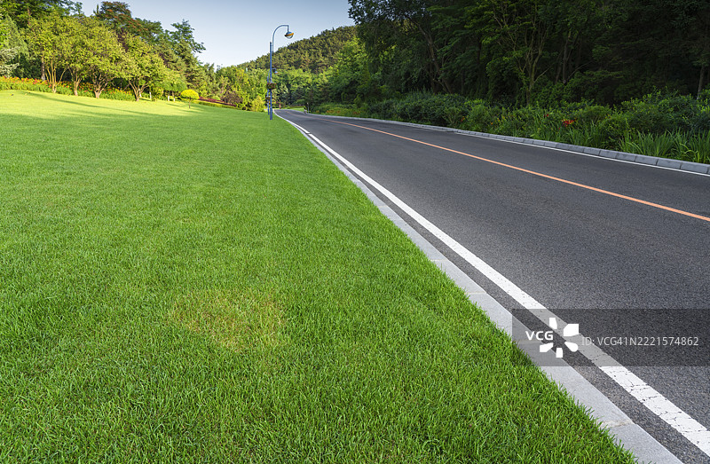 山中草地旁的笔直道路图片素材