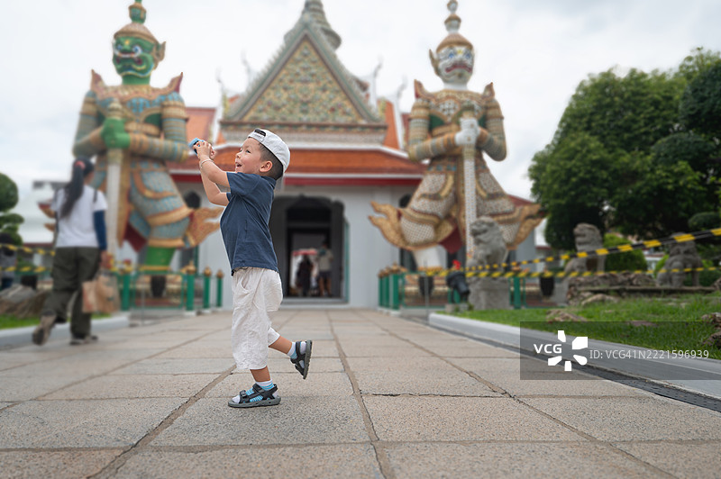 年轻男孩在泰国曼谷的华塔侬寺花园中若有所思地站着图片素材